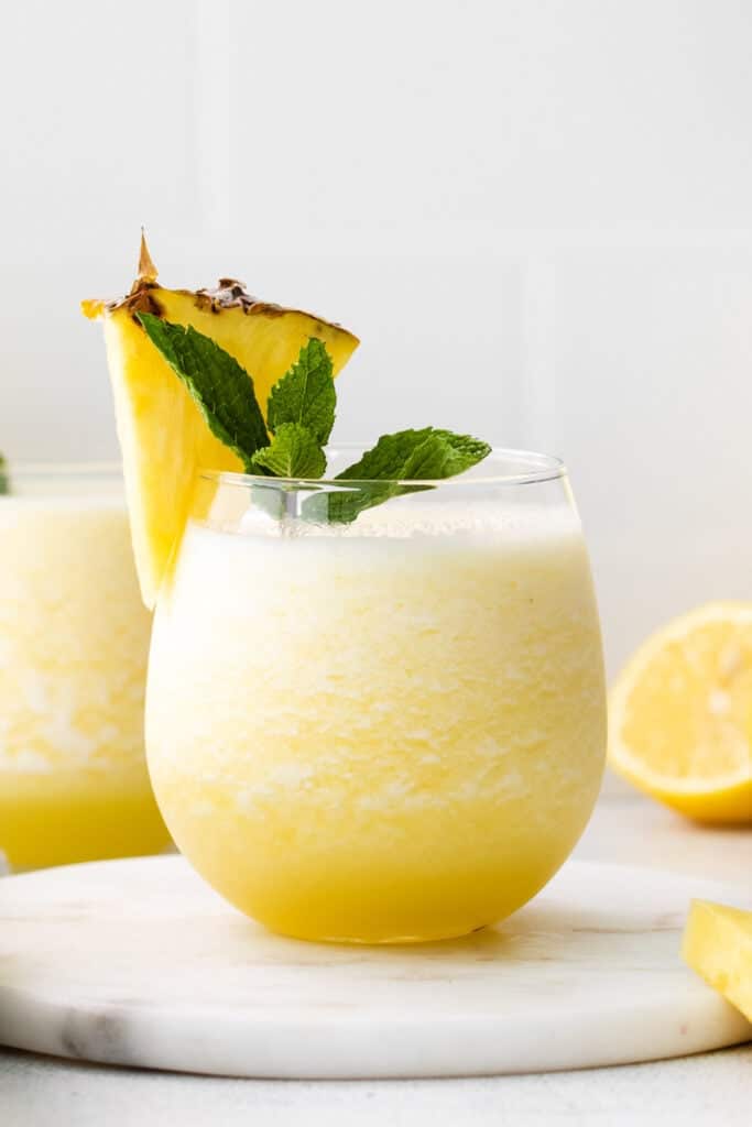 a glass of lemonade with a pineapple garnish.
