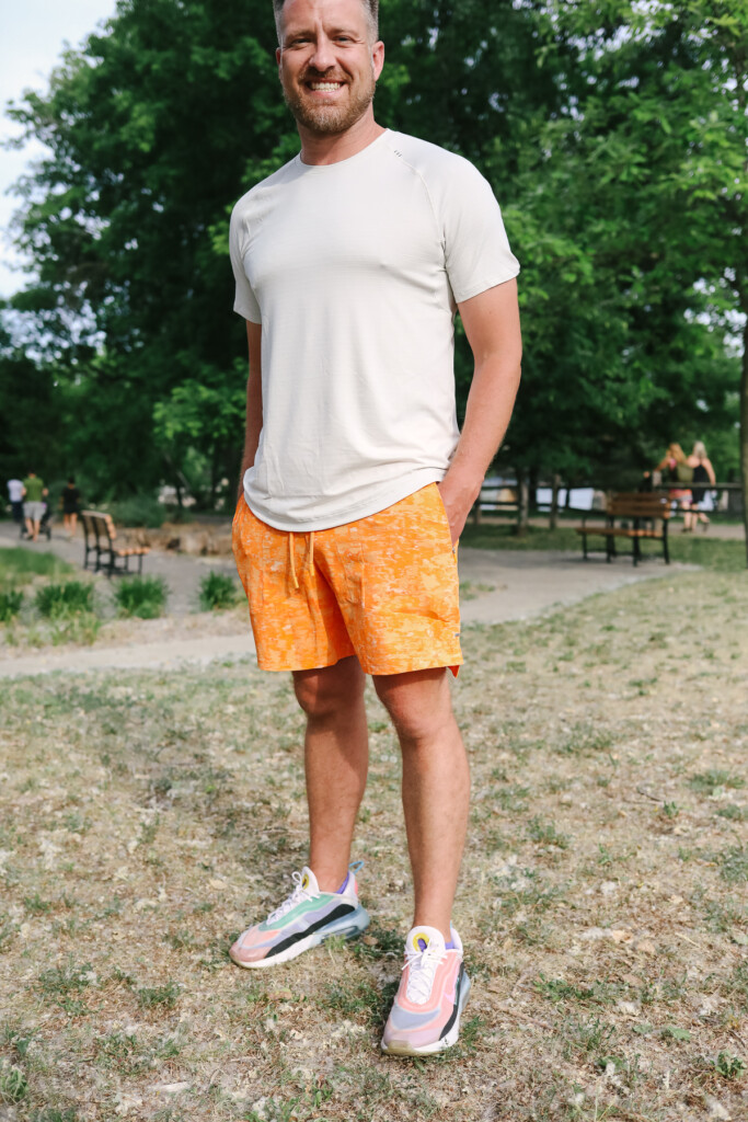 A man stands in a field with his hands in his pockets.