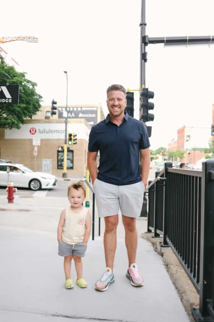 a man standing next to a little girl on a sidewalk.