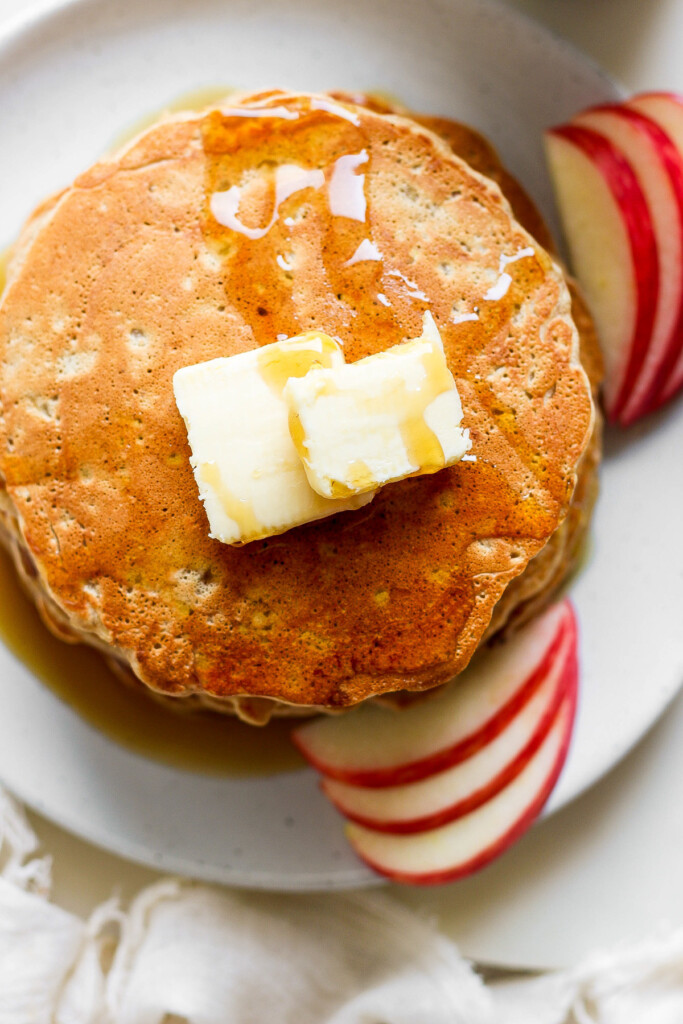 pancakes with ،er and apples on a plate.