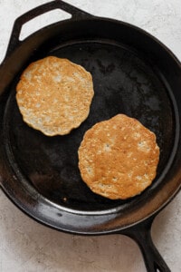 two pancakes in a cast iron skillet.