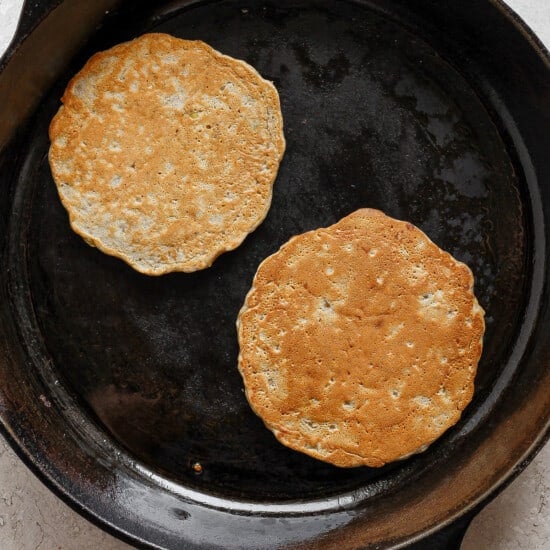 two pancakes in a cast iron skillet.
