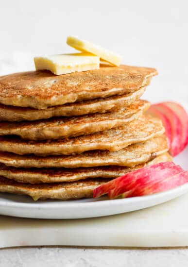 a stack of pancakes with butter on a plate.