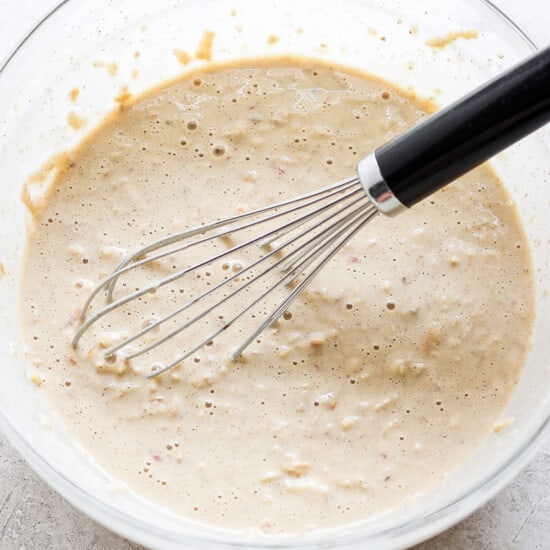 a bowl of batter with a whisk in it.