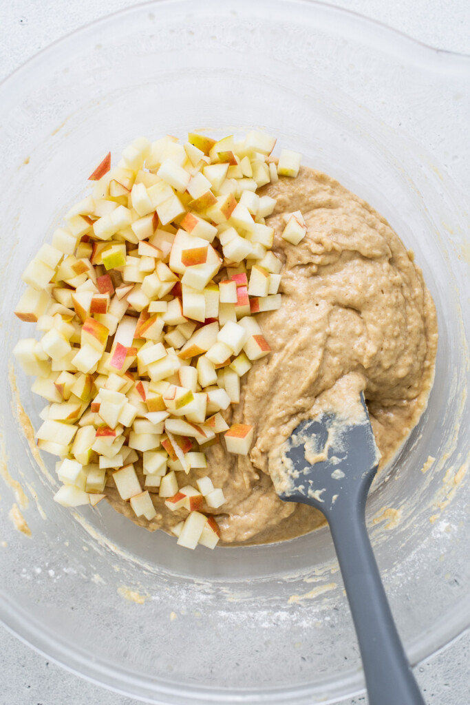 apples in a bowl with a spatula.