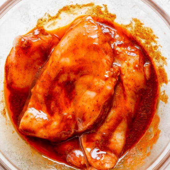 a bowl of chicken with sauce in it.