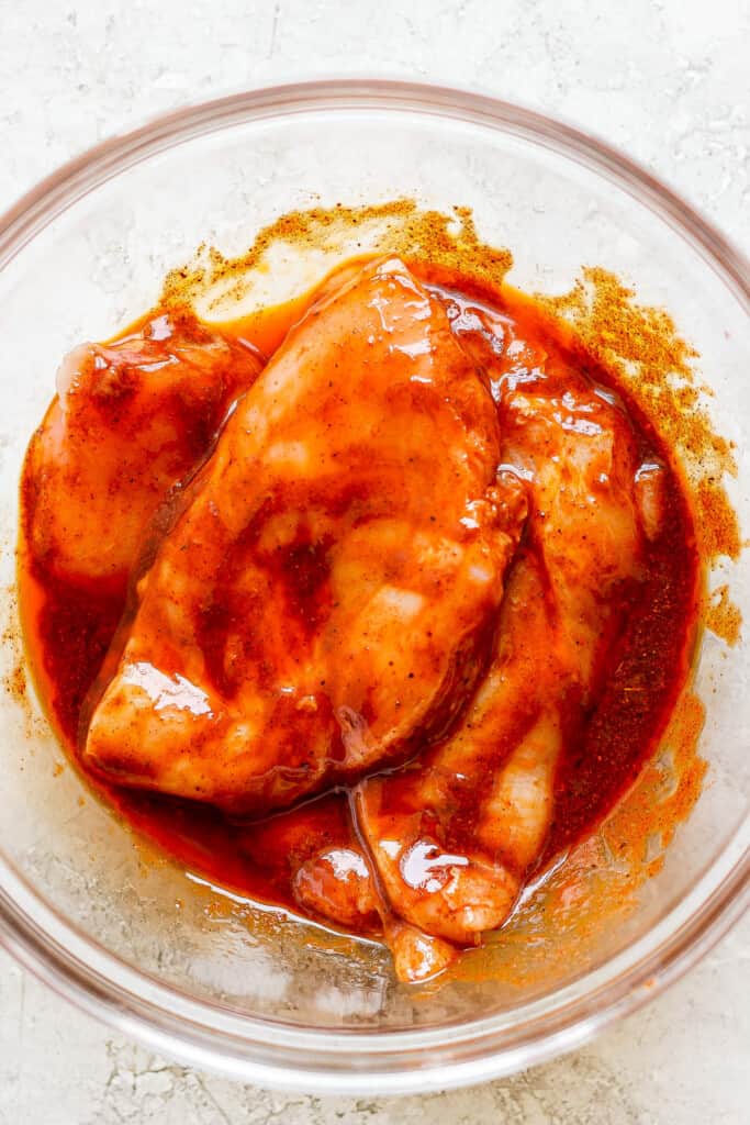 a bowl of chicken with sauce in it.