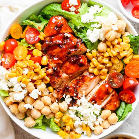 bbq chicken salad with chickpeas and tomatoes in a white bowl.