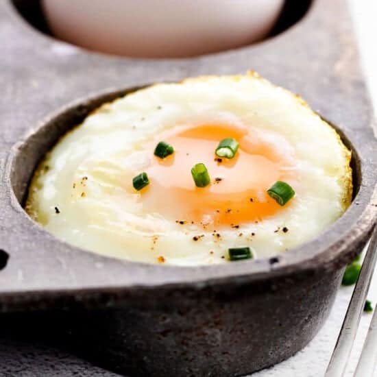 A fried egg cooked in a cast iron pan.