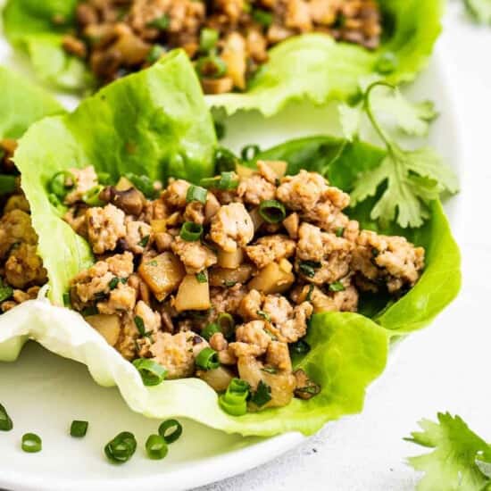 Chicken lettuce wraps with greens from PF Chang's on a white plate.