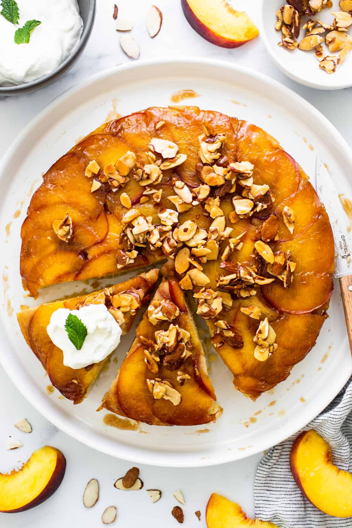 a peach upside down cake on a plate with a slice taken out.