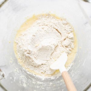 a bowl of flour with a wooden spoon in it.