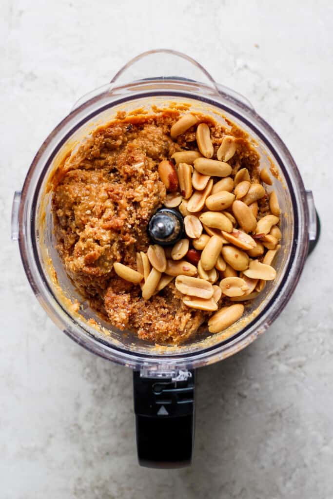 a food processor filled with peanuts and other ingredients.