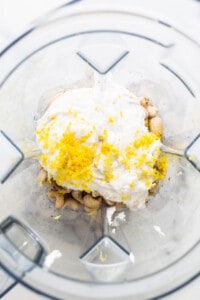 a food processor filled with lemons and nuts.