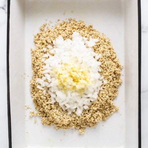A white baking dish with granola and eggs in it.