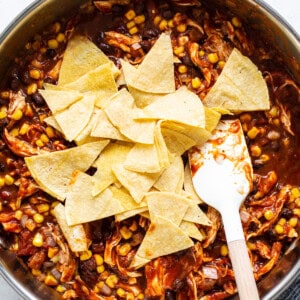 Mexican chicken enchilada in a pan with tortilla chips.