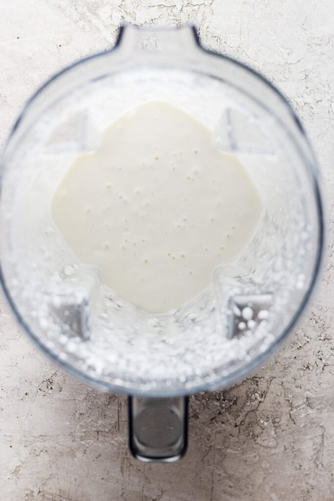 A blender with a white liquid in it.