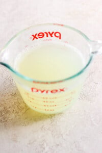 A measuring cup filled with lemon juice.