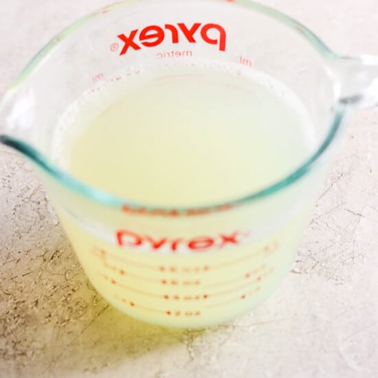 A measuring cup filled with lemon juice.