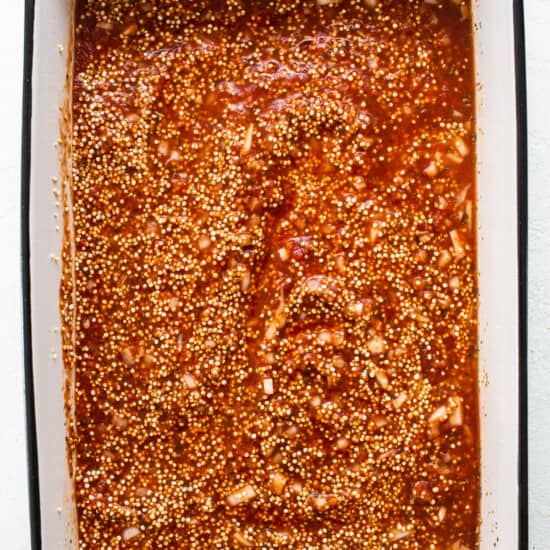A baking dish filled with sauce and spices.