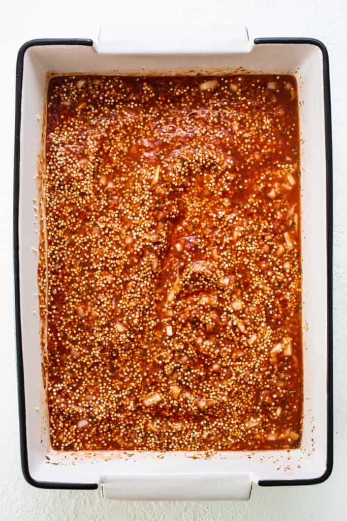 A baking dish filled with sauce and spices.