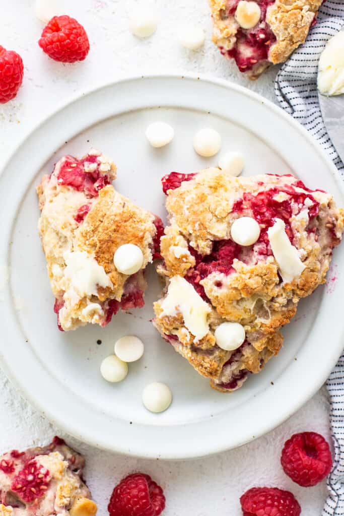 Raspberries and white chocolate slabs on a plate.