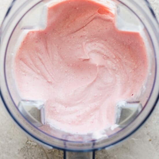 Pink whipped cream in a food processor.