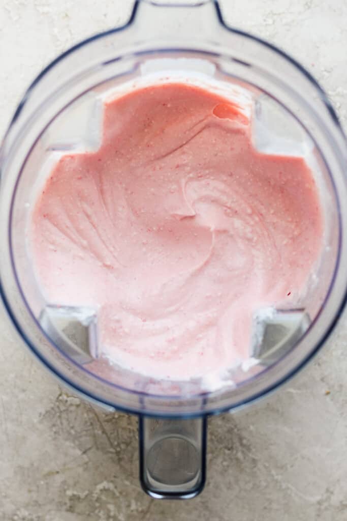 Pink whipped cream in a food processor.