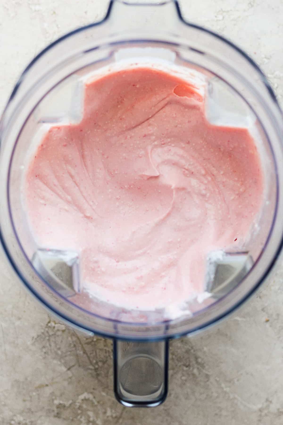 Pink whipped cream in a food processor.