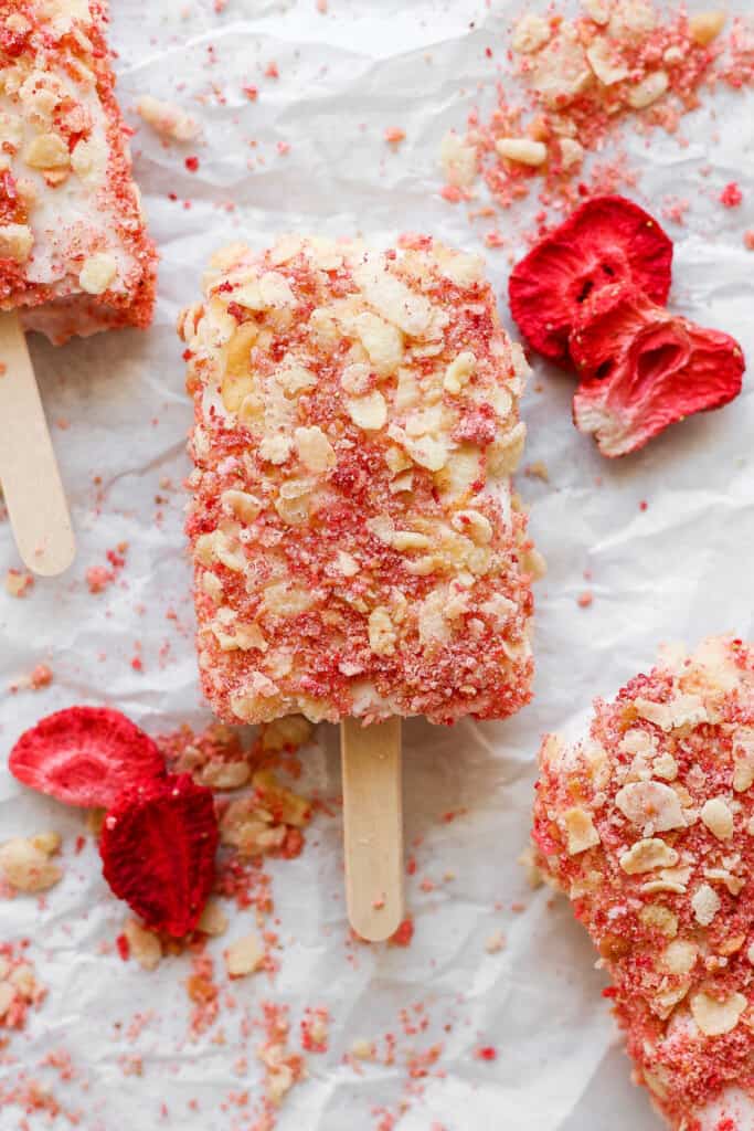 Strawberry popsicles on a sheet of paper.