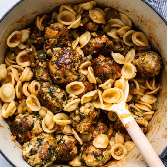A pot filled with pasta and meatballs.