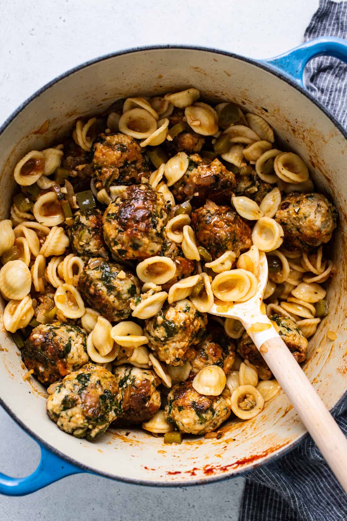 A pot filled with pasta and meatballs.