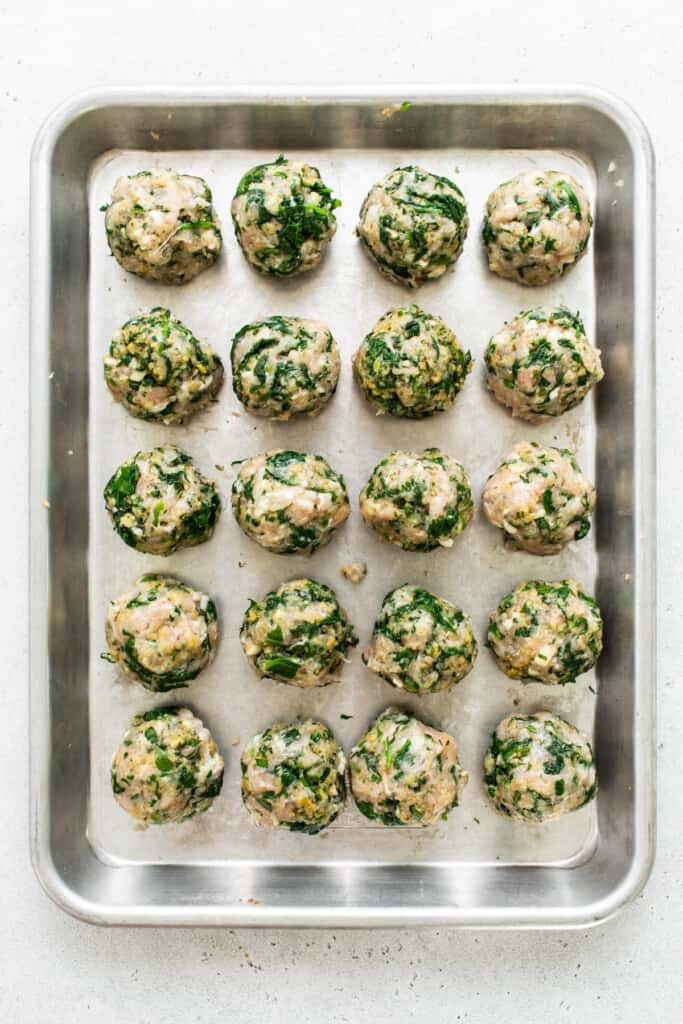 Spinach and mushroom meatballs on a baking sheet.