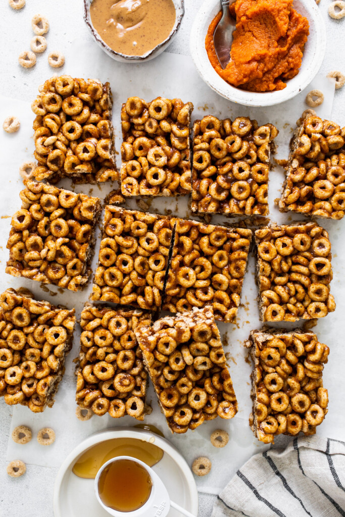 A plate of granola bars with a bowl of peanut ،er.