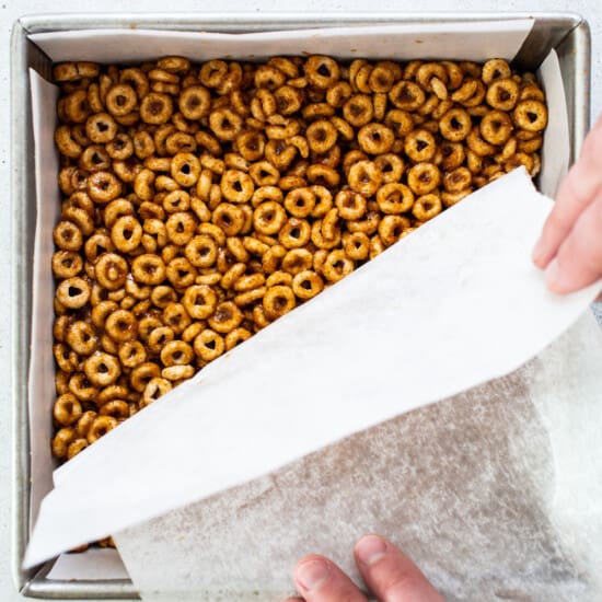 A person putting pretzels in a baking pan.