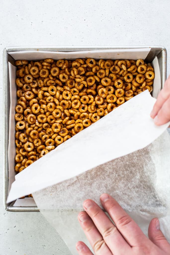 A person putting pretzels in a baking pan.
