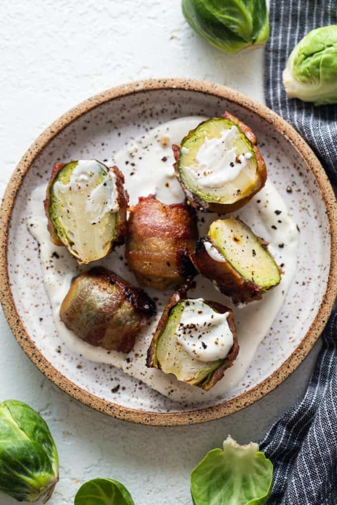 Brussels sprouts with bacon and sour cream on a plate.