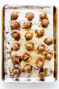 Bacon wrapped mushrooms on a baking sheet.