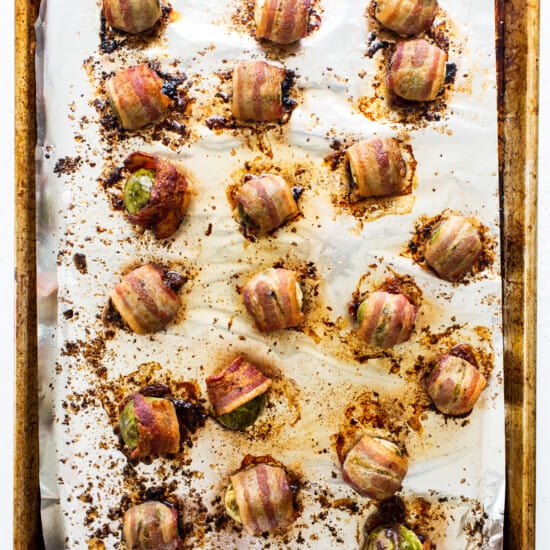 Bacon wrapped mushrooms on a baking sheet.