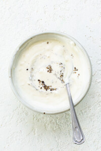 A bowl of yogurt with a spoon in it.