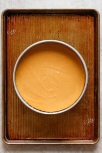 A bowl of pumpkin pie on a baking sheet.