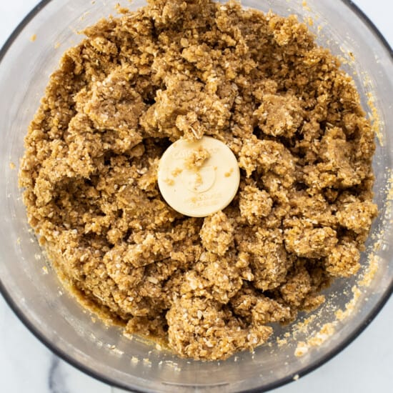 A food processor filled with oats and bananas.