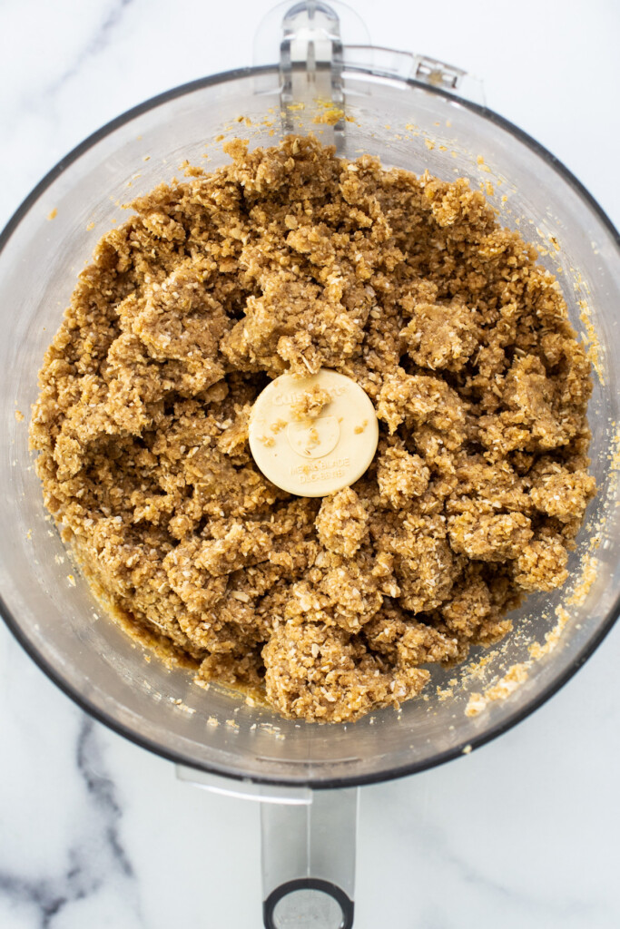 A food processor filled with oats and bananas.