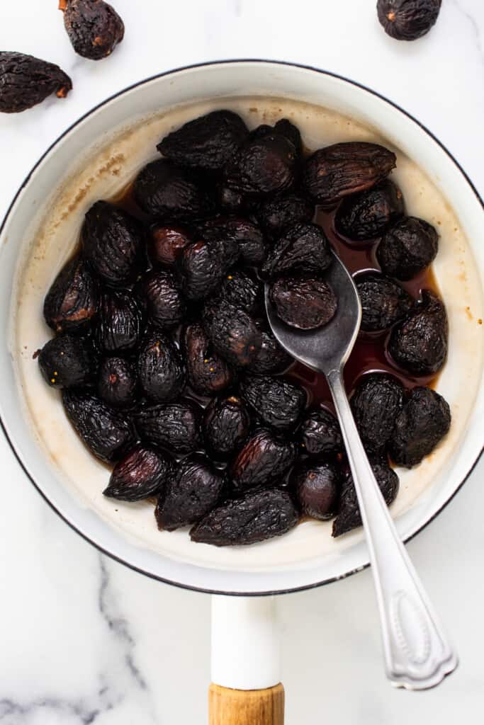 Dried figs in a pan with a spoon.