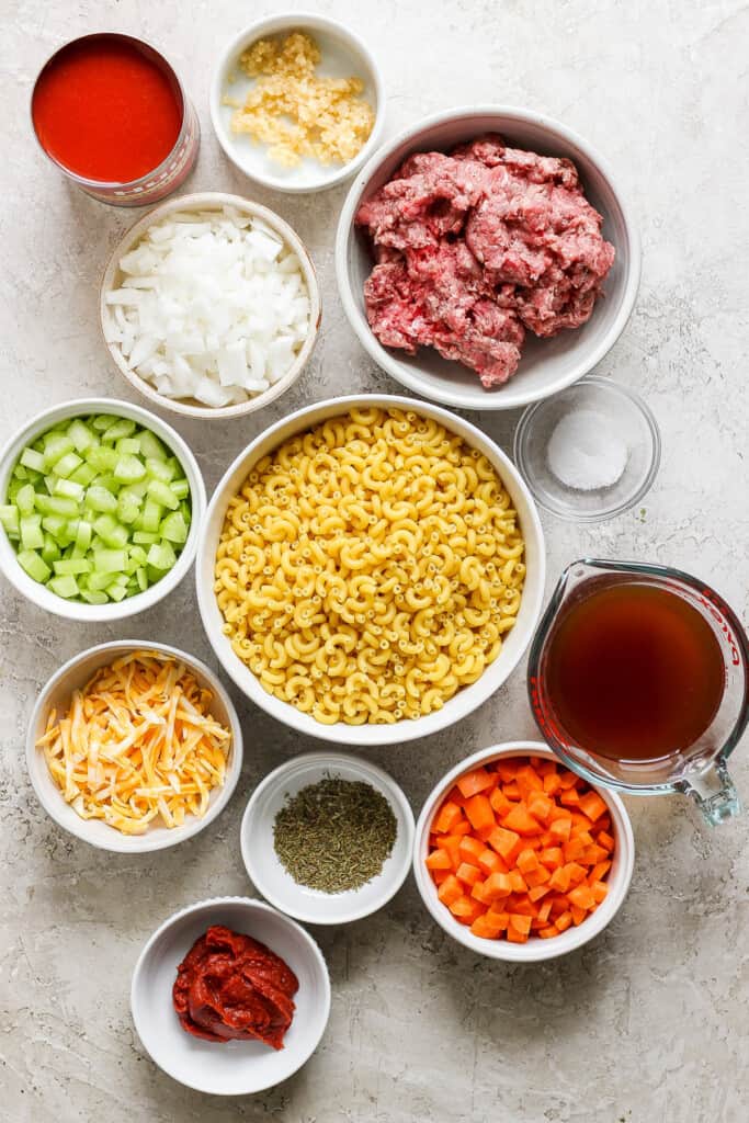Ingredients for meatballs in white bowls on a white background.
