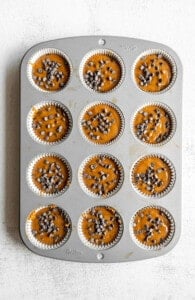 Pumpkin chocolate chip muffins in a muffin tin.