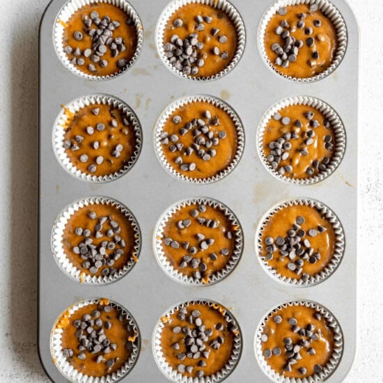 Pumpkin chocolate chip muffins in a muffin tin.