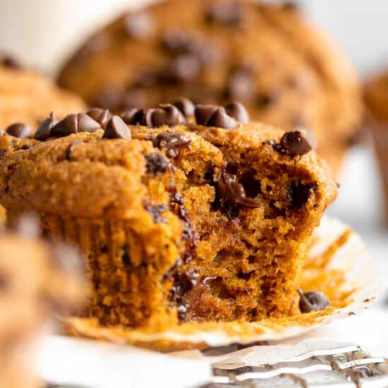Pumpkin chocolate chip muffins with a bite taken out.