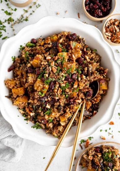 Cranberry quinoa salad with cranberries and nuts in a white bowl.