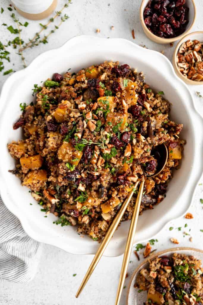 Cranberry quinoa salad with cranberries and nuts in a white bowl.
